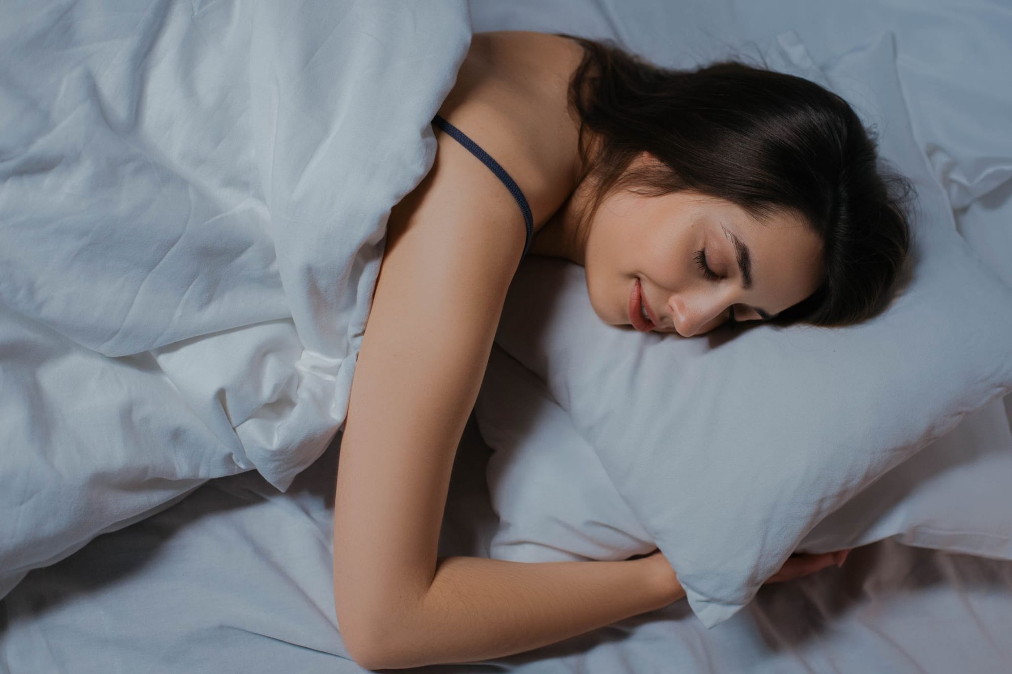 Kvinna som sover i en säng