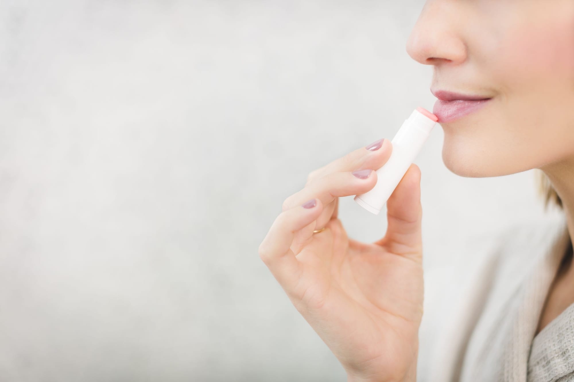 Person som använder läppbalsam mot munsår
