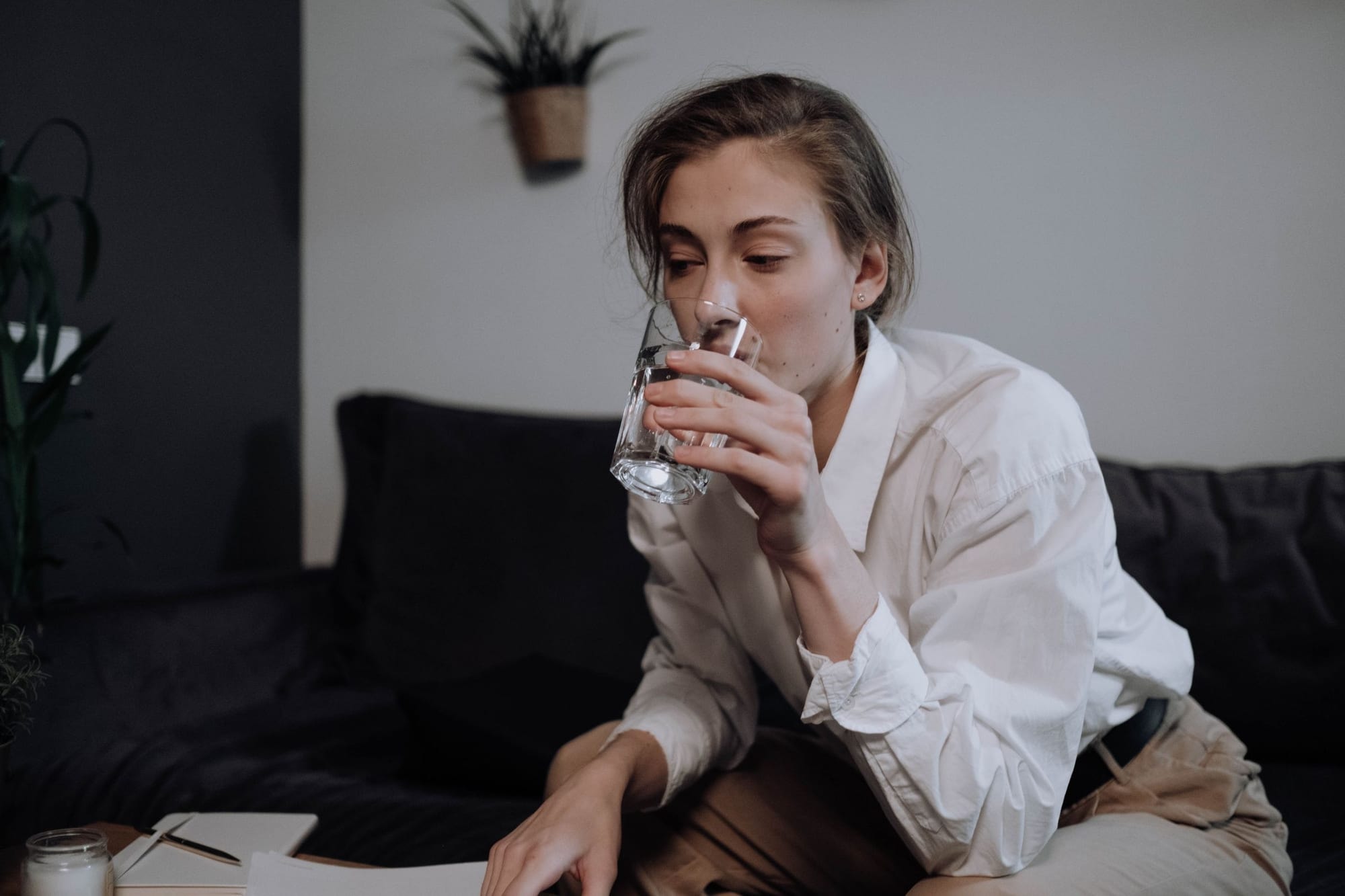 Kvinna som dricker vatten hemma