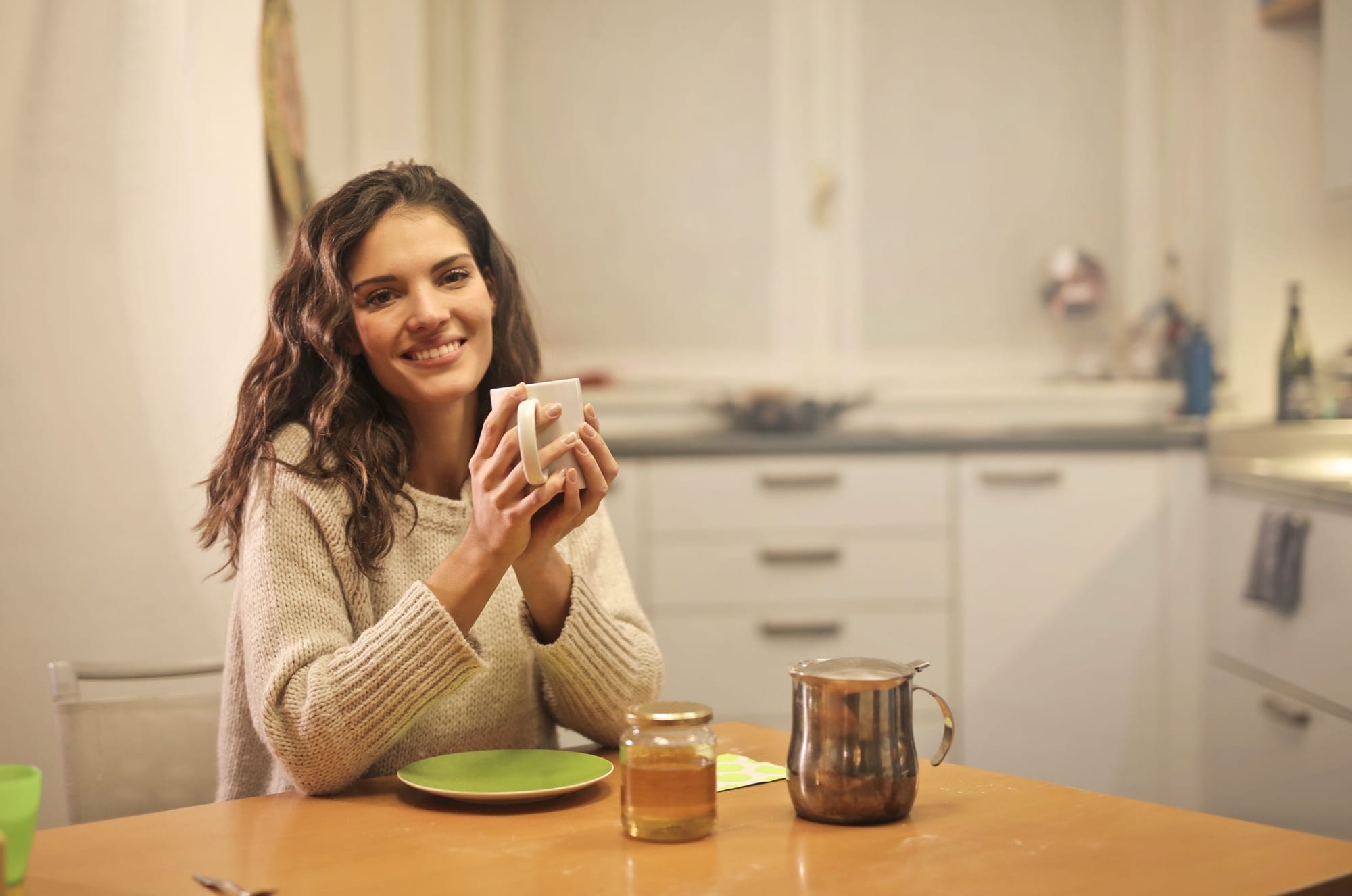 Kvinna som dricker te i köket på morgonen