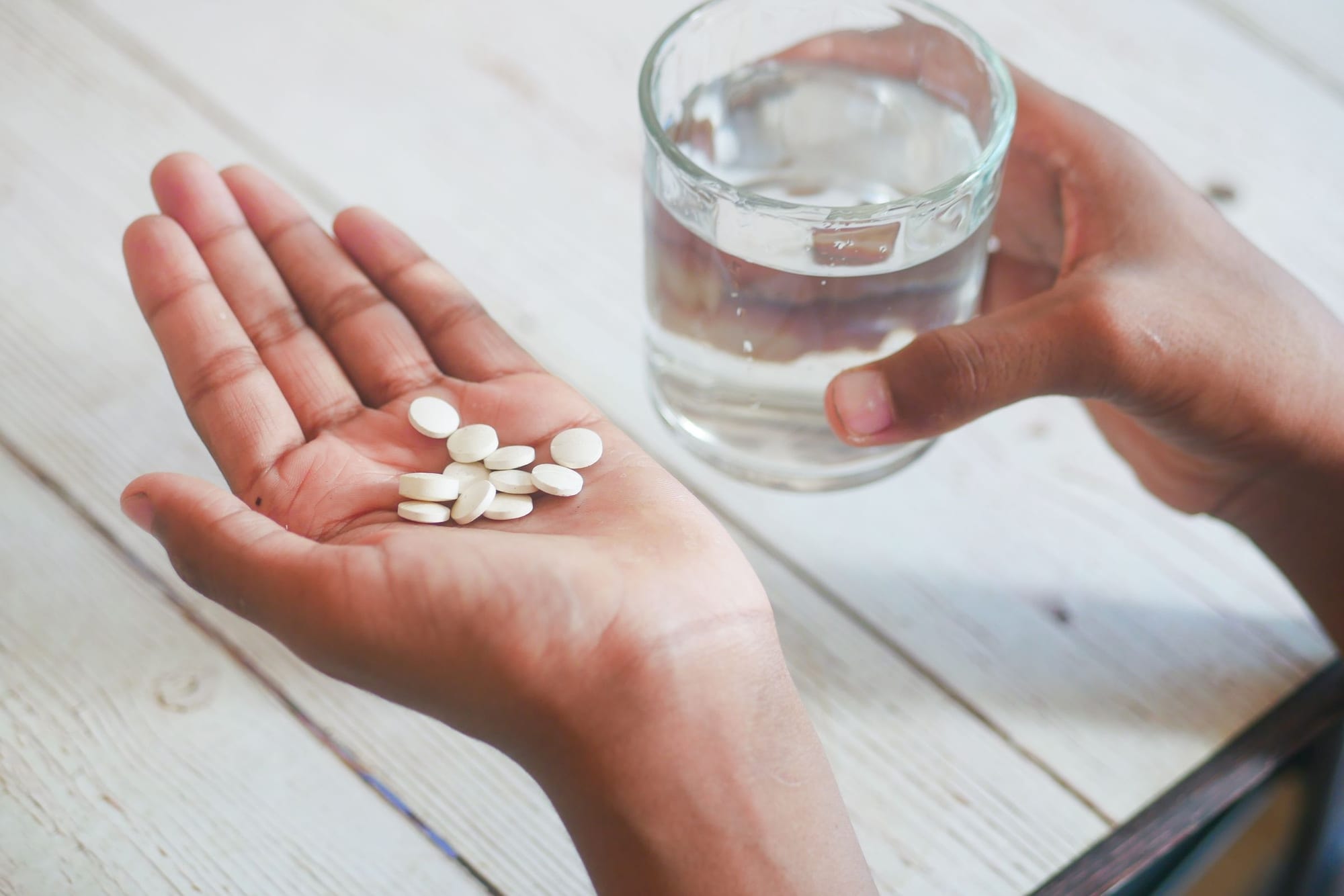 Person som tar sin medicin med ett glas vatten