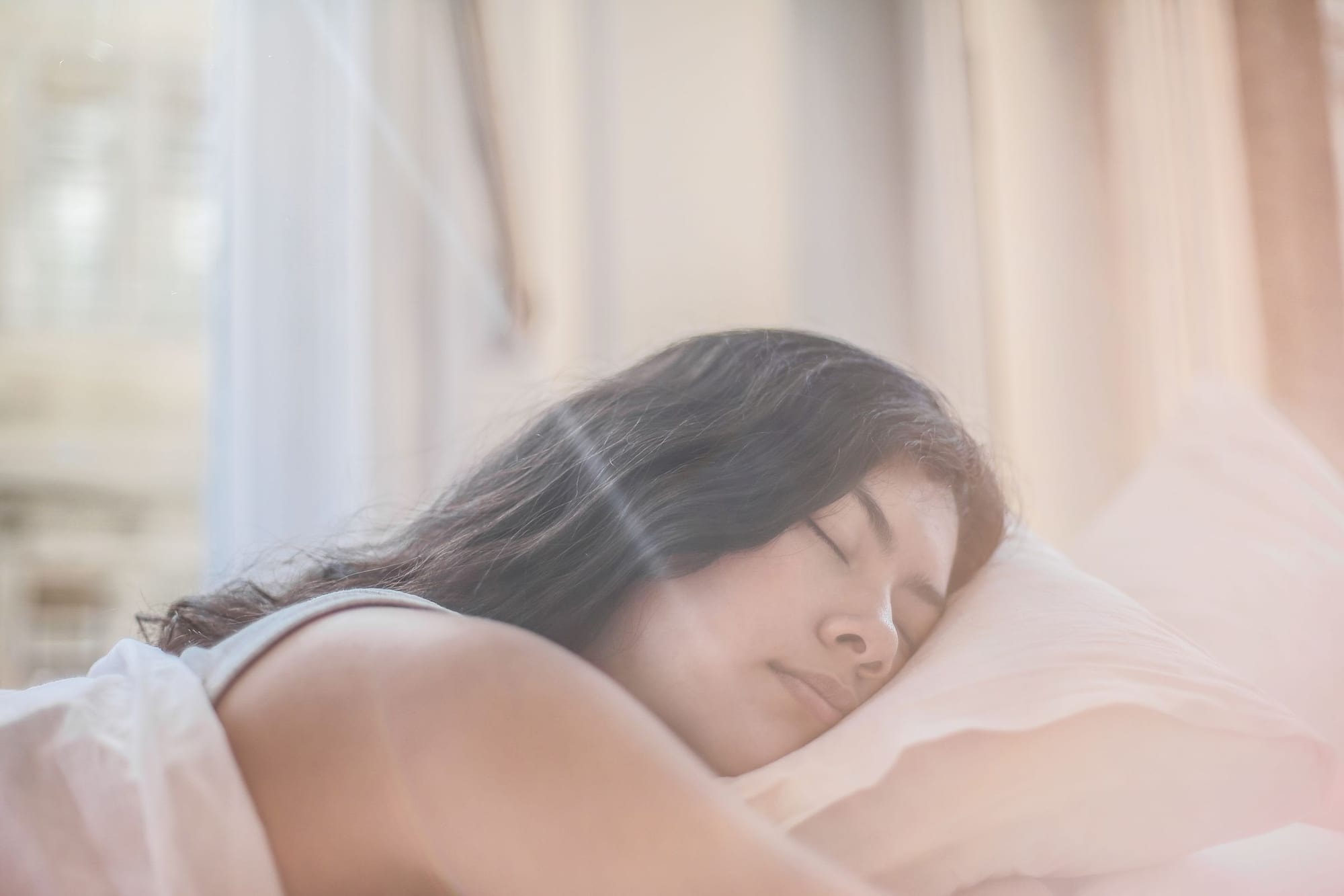 Kvinna som sover lugnt i en säng