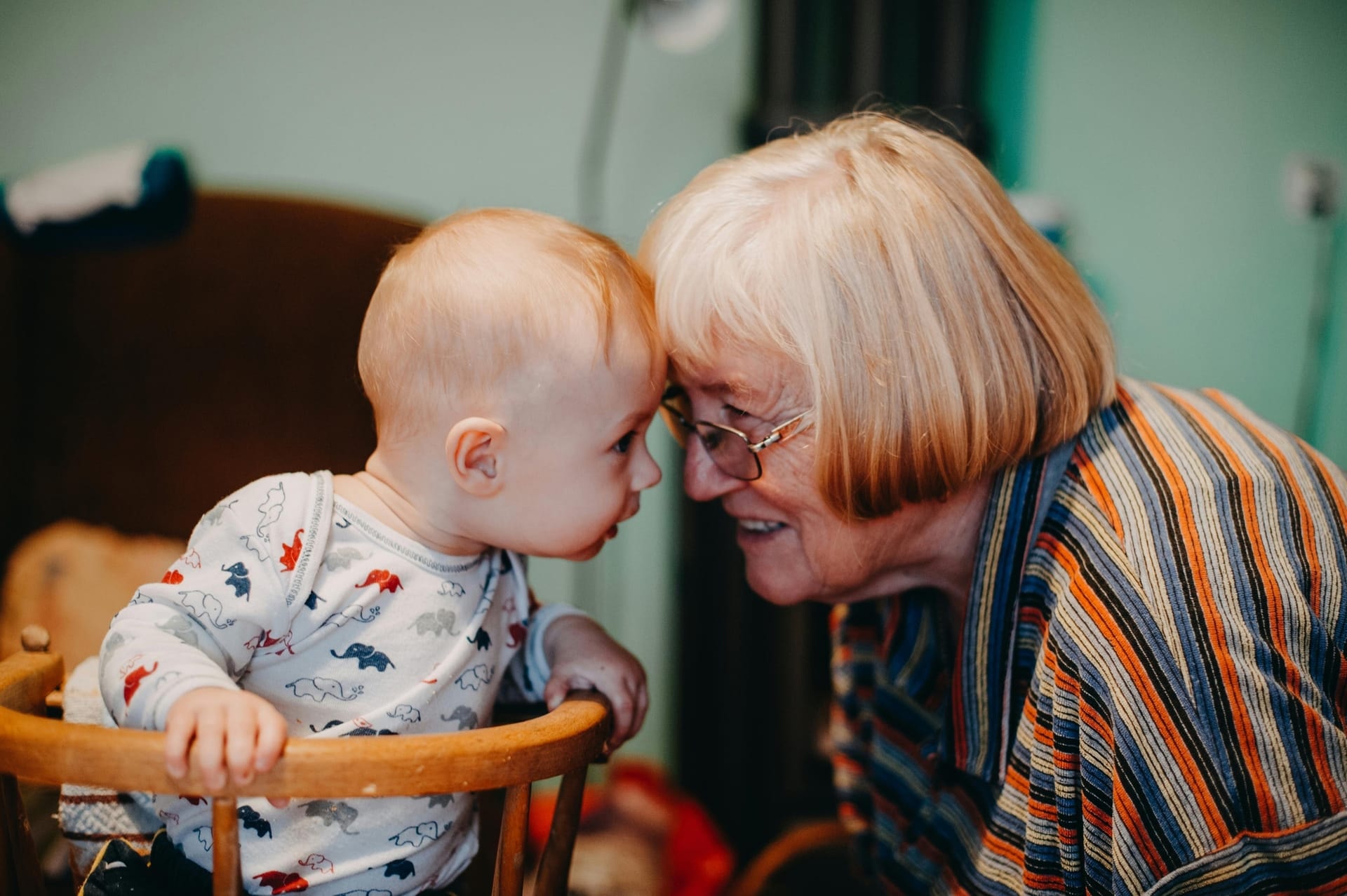 Mormor och barnbarn som gosar panna mot panna