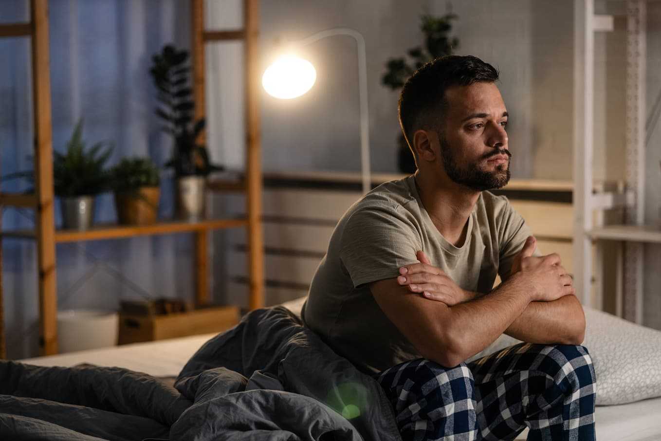 Man sitter fundersam på sängkanten – artikel om erektionsproblem efter prostatacancer, orsaker och hur du kan få hjälp och behandling hos Doktera.se